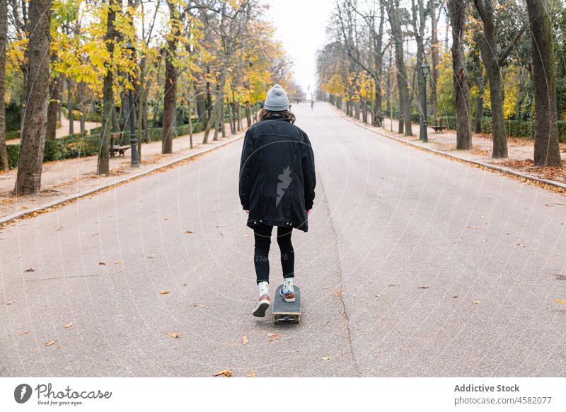 Anonyme Skaterin fährt Skateboard im Herbstpark Frau Mitfahrgelegenheit Hobby defokussiert Glück Straße Asphalt lässig Natur Park Energie Aktivität Longboard