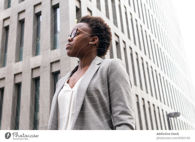 Stilvolle selbstbewusste schwarze Geschäftsfrau in der Nähe eines modernen Bürogebäudes Frau Unternehmer Großstadt Wolkenkratzer Straße Gebäude stilvoll