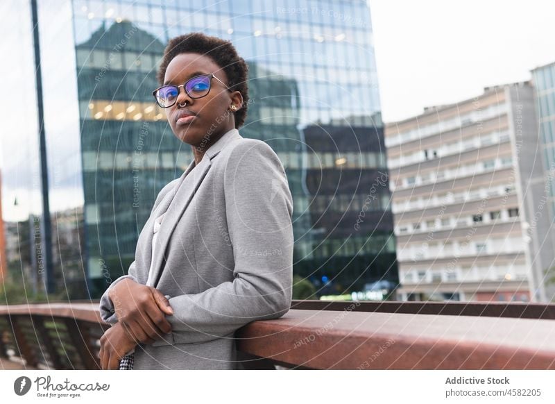 Afroamerikanische Geschäftsfrau in formellem Outfit auf dem Balkon eines Gebäudes Frau Reling Manager Großstadt ruhen trendy sich[Akk] entspannen urban Straße