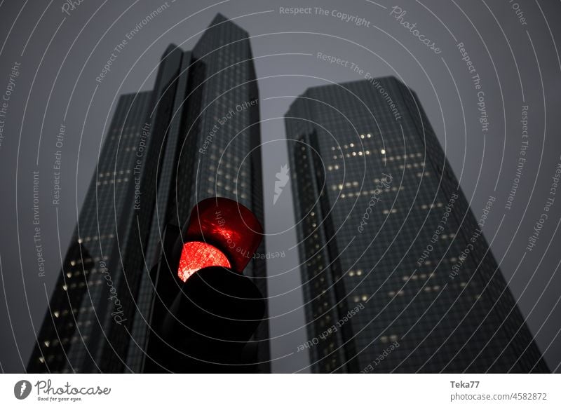 eine abendliche Skyline mit einer roten Ampel rote Ampel Rotlicht Gefahr stoppen wirtschaftliche Silhouette Abend Lichter dunkel moderne Gebäude grau Himmel