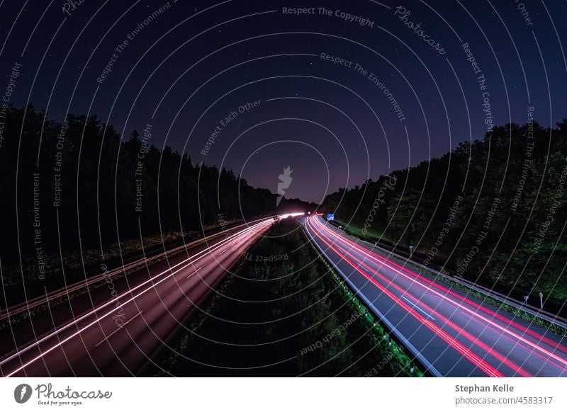 Eine deutsche Autobahn bei Nacht mit Lichtspuren der schnell fahrenden Autos in rot, Hintergrundbild für ein Hochgeschwindigkeitskonzept. Straße Verkehr