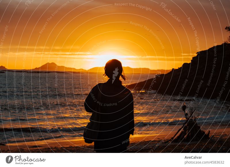 Frau steht an einem Strand während des Sonnenuntergangs und Blick auf die Inseln. Junge reisende Frau ein Hipster reisen. Mentale Gesundheit entspannen und denken über die Zukunft. Freiheit, Reisen, Urlaub