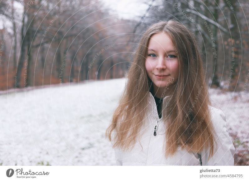 Winterliches Porträt eines langhaarigen Teenager Mädchens draussen im Park Außenaufnahme Wintertag Vorderansicht Jugendliche Junge Frau jung Winterstimmung