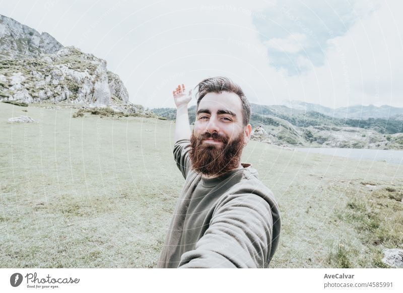 Bärtiger Mann nimmt Selfie auf dem Berg beim Wandern in den Bergen. Reisender bärtiger Mann mit Handy-Anwendung. Reisen und Lebensstil horizontal Vollbart