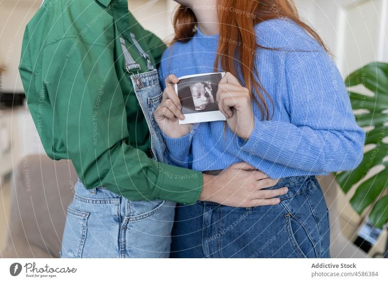 Lesben mit Ultraschallbild des Babys Frauen Paar Kuss lesbisch schwanger warten Homosexualität Partnerschaft Bild Schwangerschaft Bonden Zuneigung heimisch