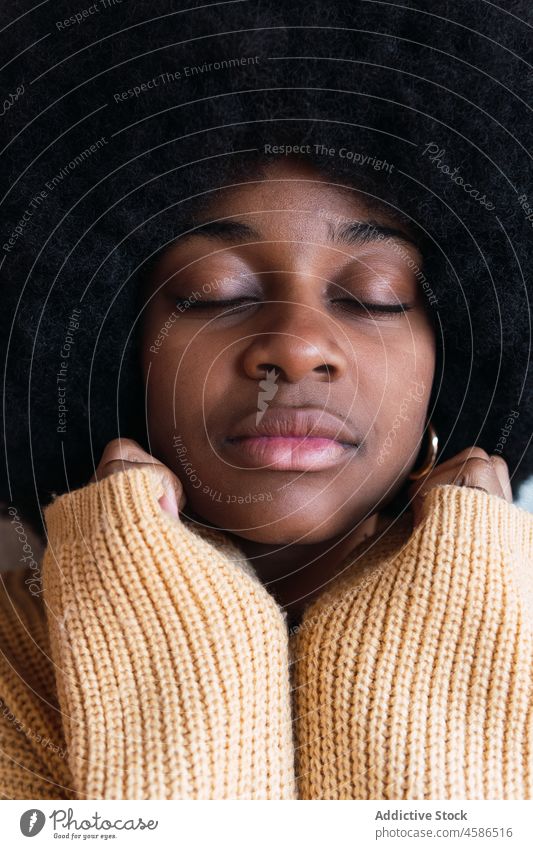 Schwarze Frau, die mit geschlossenen Augen die Hände auf ihr Gesicht stützt Porträt Afro-Look Vorschein lustig schwarz Afroamerikaner krause Haare jung