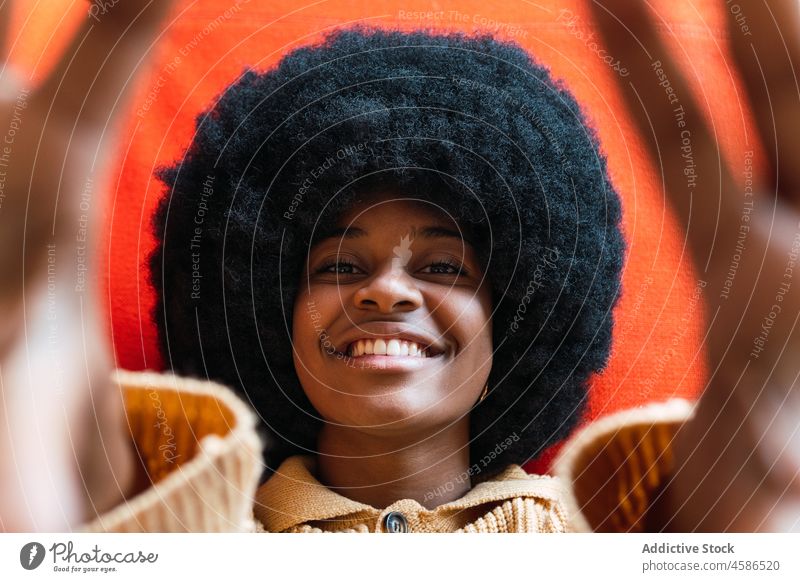 Schwarze Frau streckt die Hände in Richtung Kamera Lügen Lächeln Porträt Sofa sich[Akk] melden heiter Afro-Look Vorschein lustig schwarz Afroamerikaner