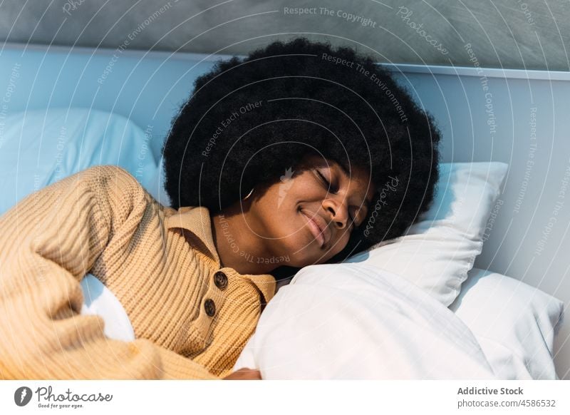 Schwarze Frau schläft auf dem Bett zu Hause schlafen heimwärts ruhen Mittagsschlaf sich[Akk] entspannen Augen geschlossen Komfort Schlafzimmer schwarz