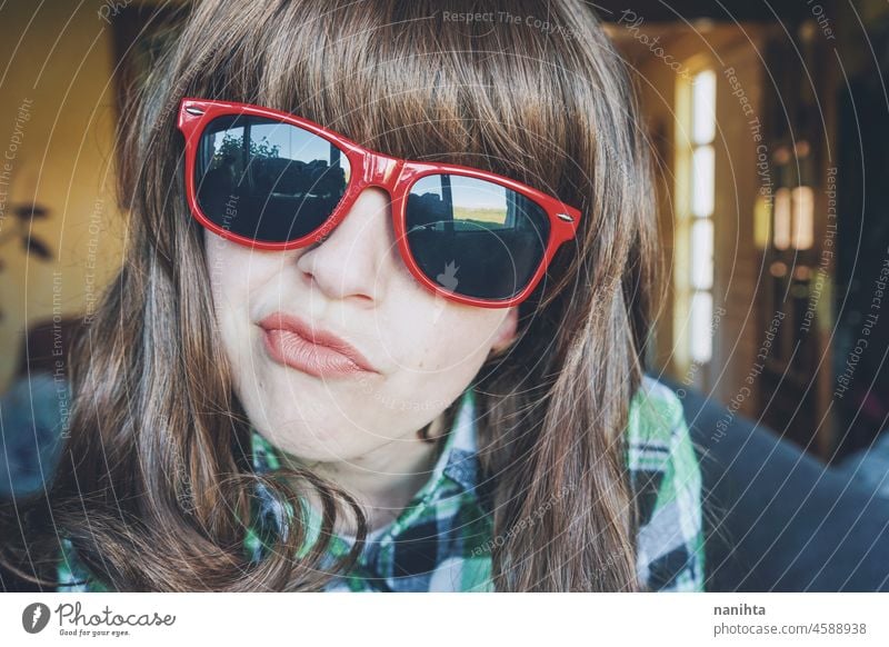 Lustiges Porträt einer jungen Frau mit roter Sonnenbrille Spaß lustig Gesicht Streberin nerdig merkwürdig schließen Kopfschuss abschließen Plaid Freak heimwärts