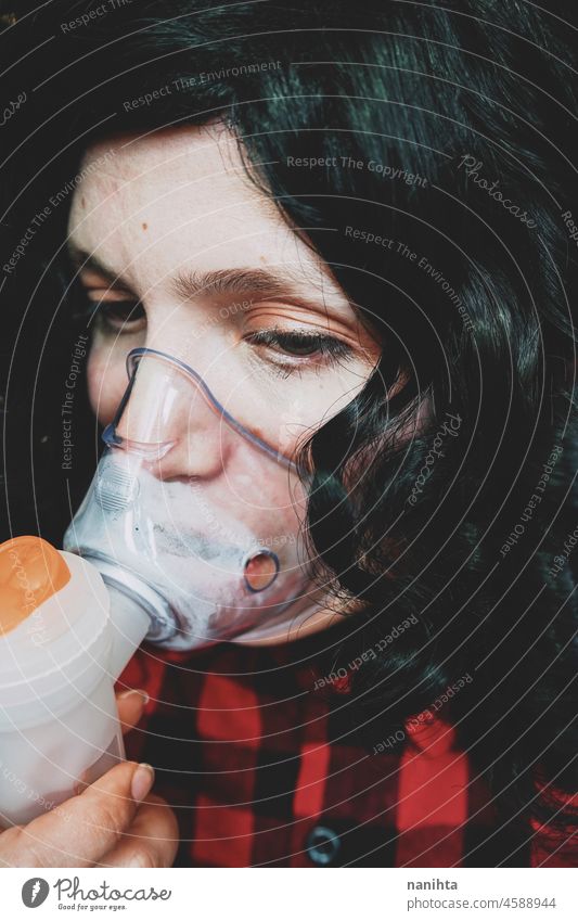 Junge Frau trägt eine Sauerstoffmaske Mundschutz medizinisch Asthma Grippe Allergie COVID Coronavirus covid-19 atmen krank Krankheit Gesundheitswesen jung