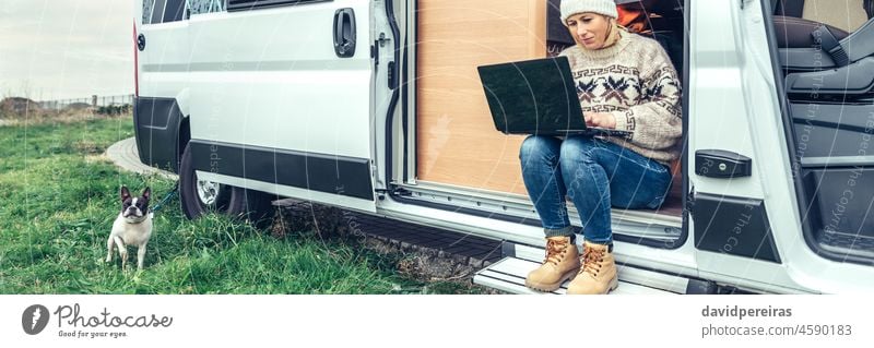 Frau bei Telearbeit in der Tür eines Wohnmobils sitzend Laptop Sitzen Kleintransporter Transparente Netz Panorama panoramisch Kopfball Textfreiraum Ausflug