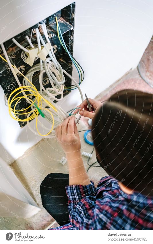 Unbekannte Technikerin bei der Installation eines Lan-Netzwerks Draufsicht Frau unkenntlich Installateur Telekommunikation lan Kabel Telekommunikationsbox