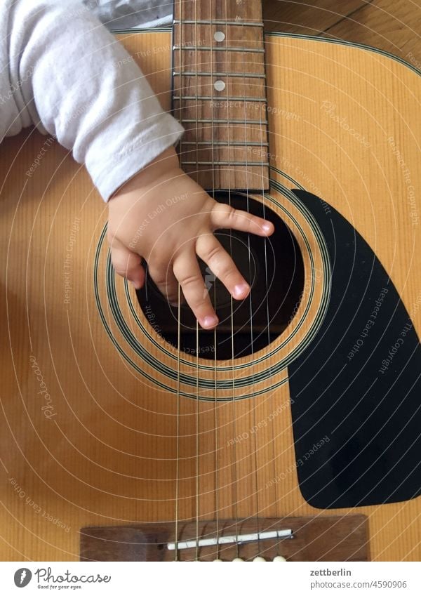 Das Baby spielt sehr gut Gitarre baby kind kleinkind hand finger greifen begreifen gitarre instrument musik musikinstrument saite saiteninstrument schallloch