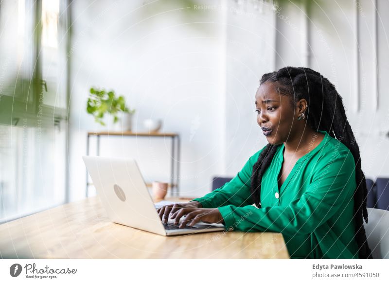 Frau arbeitet am Laptop in ihrem Büro schwarz Jahrtausende Hipster im Innenbereich Loft Fenster natürlich Erwachsener eine attraktiv gelungen Menschen