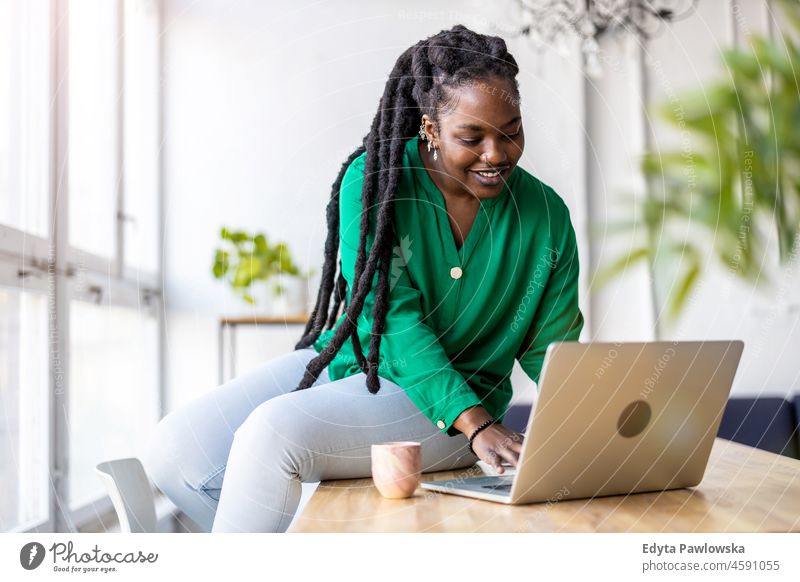 Frau arbeitet am Laptop in ihrem Büro schwarz Jahrtausende Hipster im Innenbereich Loft Fenster natürlich Erwachsener eine attraktiv gelungen Menschen