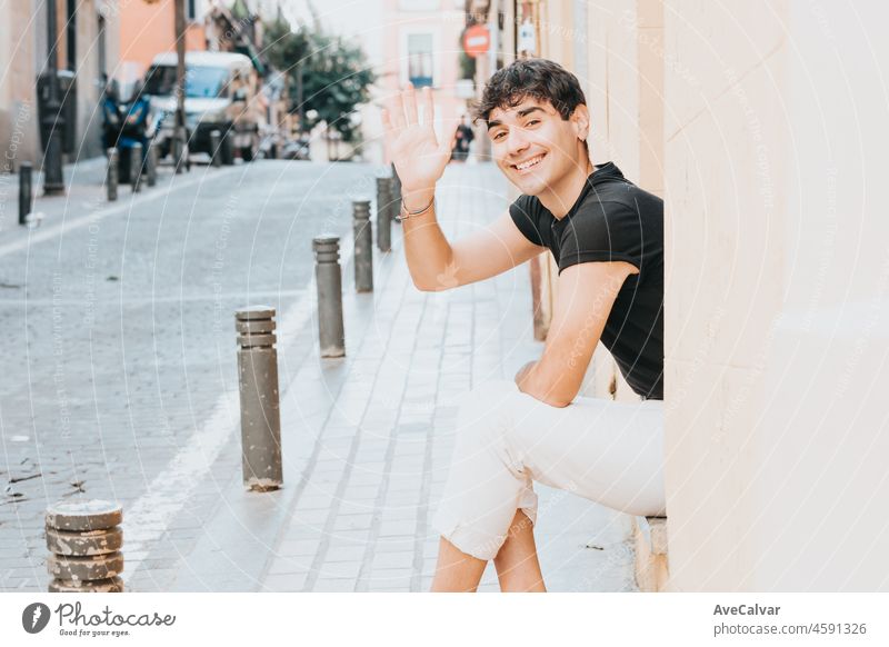 Fröhlicher Mann grüßt in die Kamera im Freien mit Kopierraum. Stadt Madrid. Glücklich Lebensstil Konzept. Glücklich mit neuen Gewohnheiten Gruß