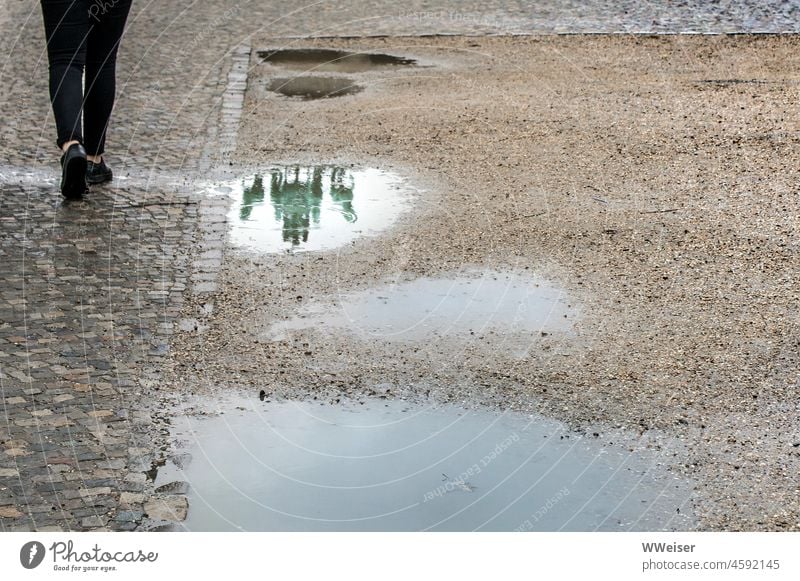 In der Pfütze spiegelt sich ein Wahrzeichen von Berlin Pariser Platz Brandenburger Tor Hauptstadt Passant Beine Ausschnitt vorbeigehen Regen Wetter regnerisch