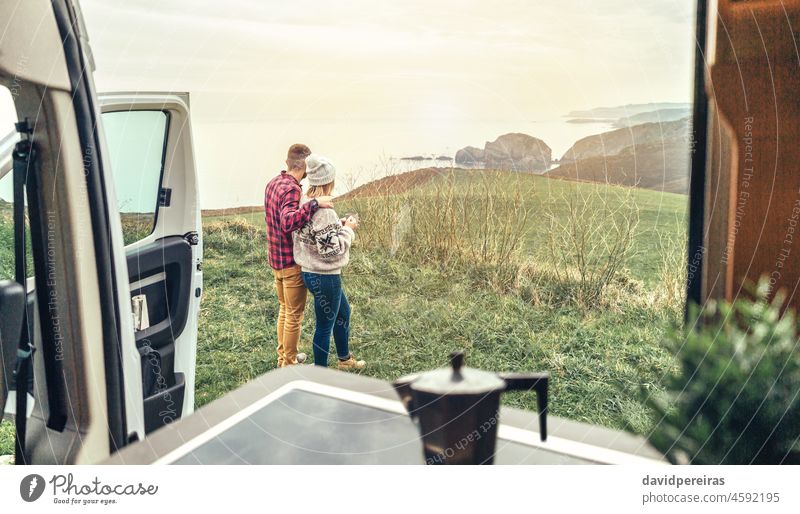 Unbekanntes Paar reist im Wohnmobil und schaut auf die Küstenlandschaft unkenntlich Kleintransporter Blick Landschaft Küstenlinie MEER Morgen Morgendämmerung
