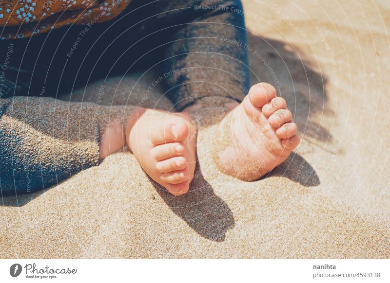 Nahaufnahme der Beine und Füße eines Babys, das über der Sonne sitzt Fuß Strand Sand Gesundheit sonnig Urlaub Feiertage Pflege Haut blass weiß Kaukasier spielen