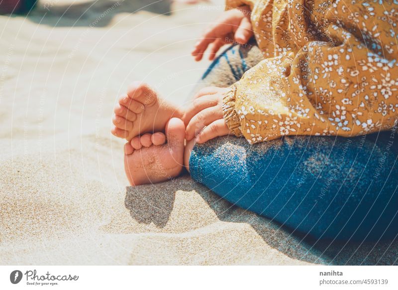 Nahaufnahme der Beine und Füße eines Babys, das über der Sonne sitzt Fuß Strand Sand Gesundheit sonnig Urlaub Feiertage Pflege Haut blass weiß Kaukasier spielen