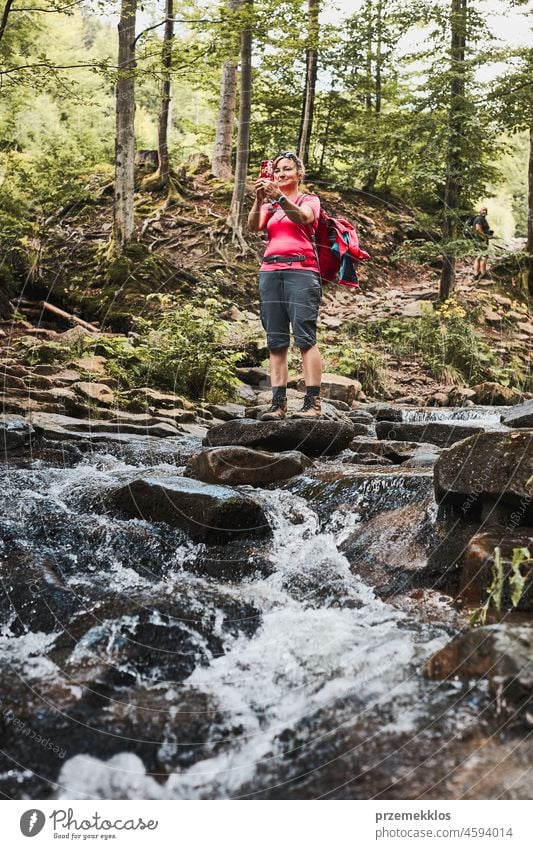 Fotos aus dem Urlaub machen. Frau mit Rucksack, die mit einer Smartphone-Kamera Fotos von der Landschaft macht Sommer Ausflug Berge u. Gebirge reisen Reise