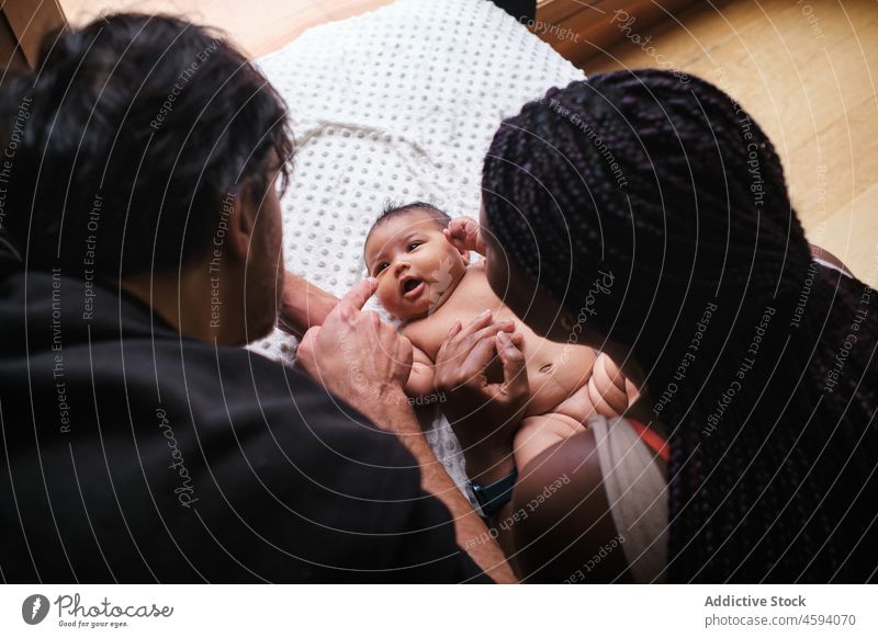 Schwarze Mutter wickelt ihr Baby mit ethnischem Vater Familie Windel Wandel & Veränderung Pflege Liebe Elternschaft Mama Bonden Streicheln unschuldig