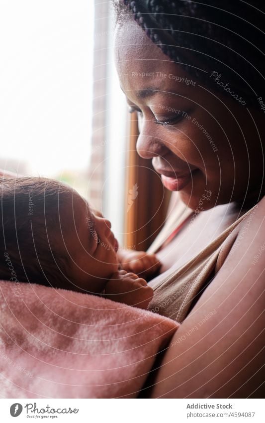Afroamerikanische Frau küsst neugeborenes Baby auf die Hände Kuss Kind Angebot Mutter Pflege Liebe Fenster heimwärts Umarmung Eltern Komfort Umarmen Handtuch