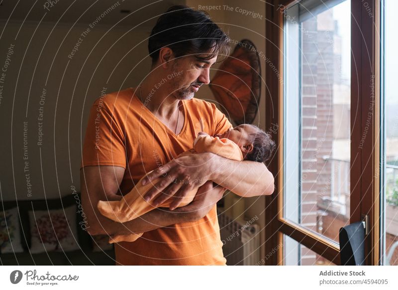Fürsorglicher ethnischer Vater hält kleines Baby Säugling Streicheln niedlich Pflege Bonden Liebe Angebot Mann neugeboren Papa Bär Kind Zusammensein Kindheit