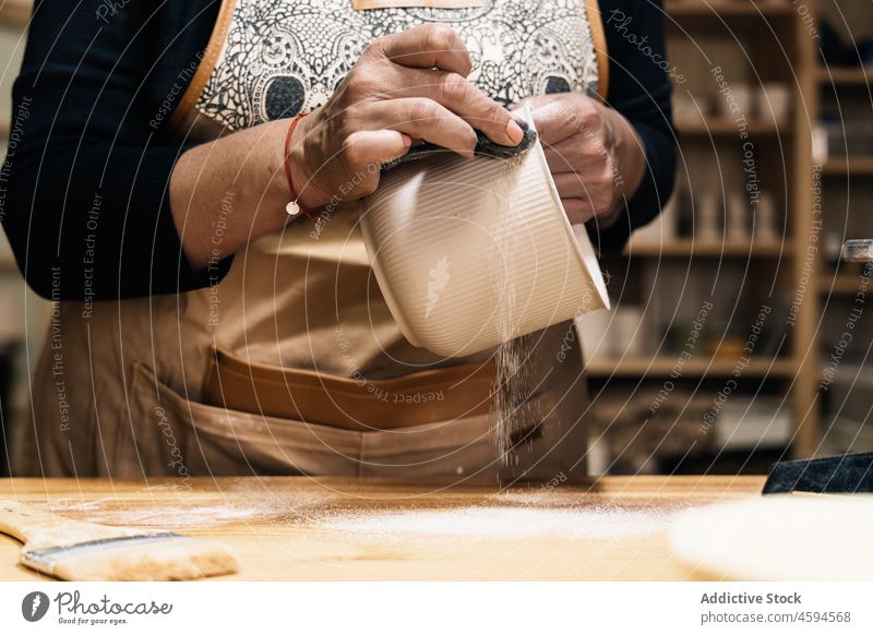 Kunsthandwerker bei der Herstellung von Tontöpfen Handwerkerin Topf Schürze Basteln Tisch Werkstatt Töpferwaren Hobby handgefertigt Frau Handarbeit