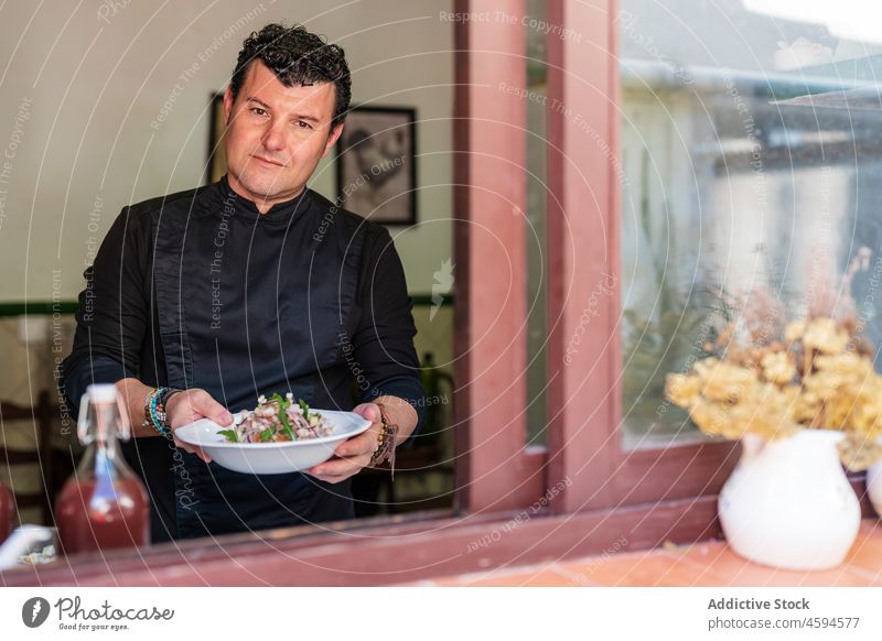 Mann demonstriert leckeren Salat im Restaurant Salatbeilage Speise Teller Lebensmittel Anlasser Fenster positiv männlich Mahlzeit geschmackvoll Mittagessen