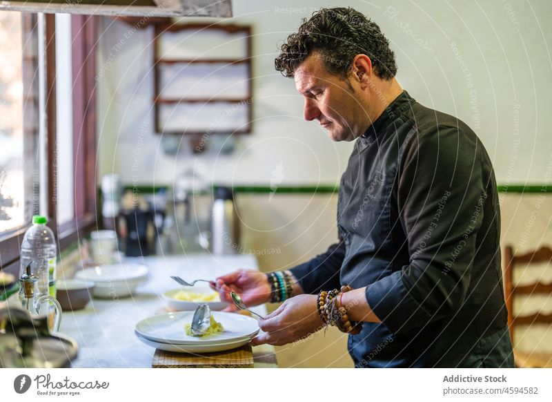 Seriöser Mann serviert Essen im Restaurant Küchenchef Lebensmittel Uniform lecker professionell Teller kulinarisch männlich Koch dienen vorbereiten Arbeit Job