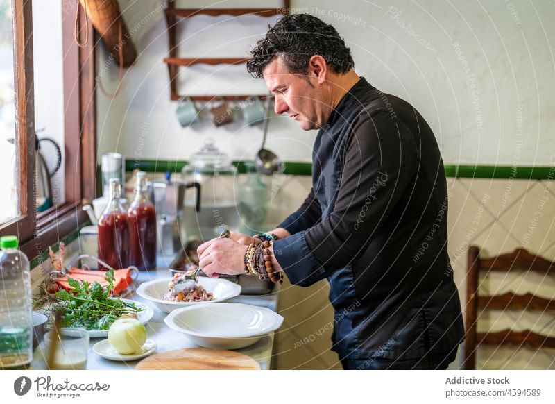 Mann serviert leckeres Essen in der Küche Lebensmittel Küchenchef Gastronomie professionell Restaurant sortiert Bestandteil männlich dienen geschmackvoll Teller