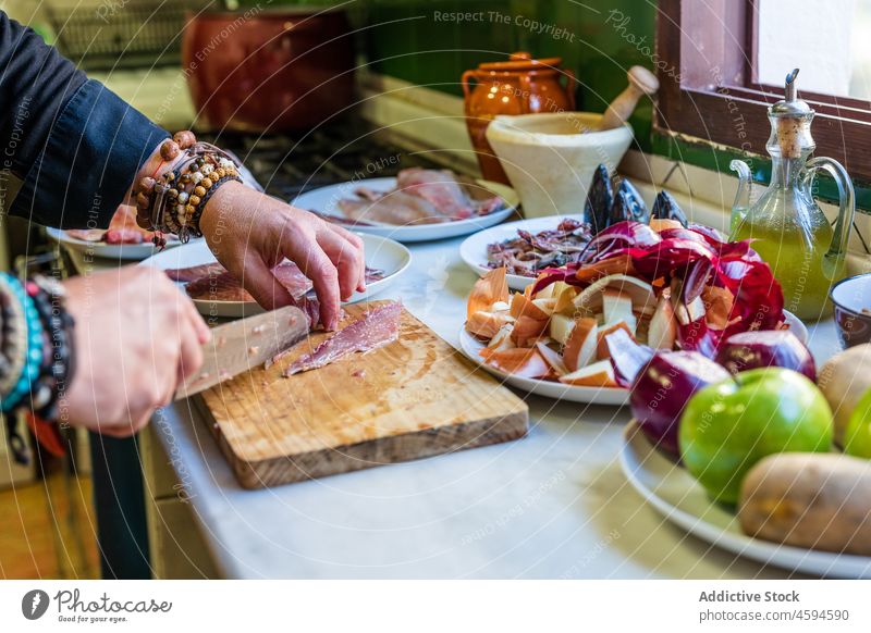 Anonymer Koch schneidet Fisch an Bord Mann Lebensmittel Küchenchef Bestandteil kulinarisch sortiert Schneidebrett Arbeit männlich geschnitten Uniform
