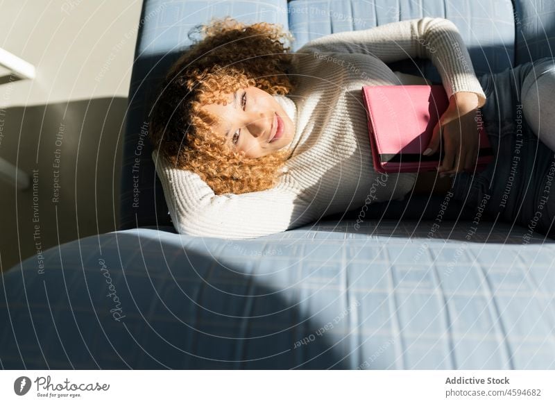 Schwarze Dame schlafend auf Sofa mit Tablette Frau Liege Schlummer Komfort ruhen sich[Akk] entspannen Mittagsschlaf Kälte ethnisch Apparatur räkeln Wohnzimmer