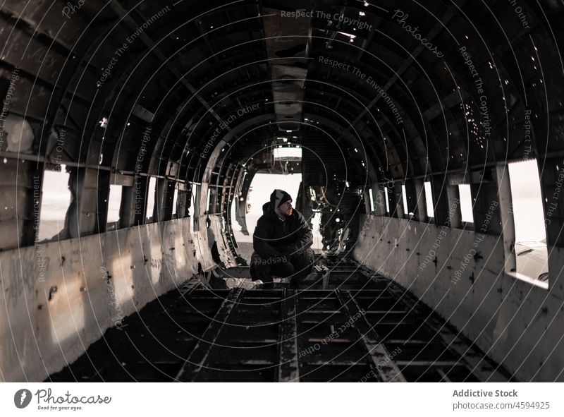 Mann sitzt in der Kabine eines abgestürzten, zerstörten Flugzeugs Reisender Unfall Schaden Ebene Absturz Wrackteile verfallen Verlassen männlich gebrochen