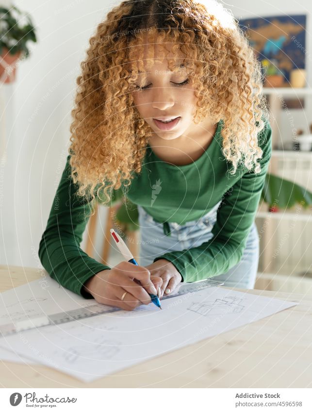 Ethnische Frau zeichnet mit Stift und Lineal auf Papier zeichnen Designer Schreibstift Skizze Konzentration Prozess kreativ Arbeit professionell Beruf Atelier
