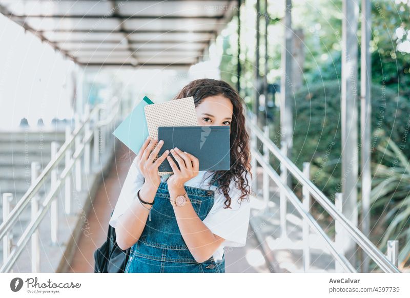 Universität Eintrag Porträt eines intelligenten schönen arabischen Mädchen hält Studie Text Bücher lächelnd Blick auf die Kamera. Authentic Student hat eine Menge zu studieren und zu lesen, für Klasse Assignment, Prüfungen Vorbereitung