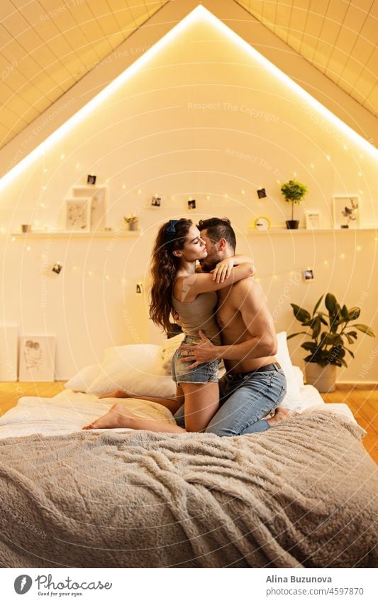Schönes leidenschaftliches junges Paar umarmt auf dem Bett zu Hause. Intime und sinnliche Momente eines Paares, das sich im Schlafzimmer liebt. Bleiben Sie während der Coronavirus-Covid-19-Sperre zu Hause.