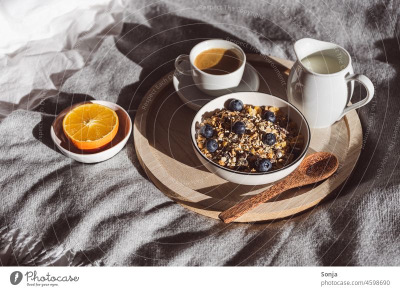 Frühstück im Bett mit Müsli, Obst und Milch auf einem Serviertablett Schüssel Kaffee orange Gesunde Ernährung Farbfoto Bettwäsche weiß zuhause Hygge gemütlich