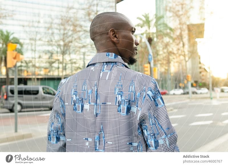Stilvoller schwarzer Mann auf der Straße Großstadt Mode urban Outfit trendy Bekleidung männlich Afroamerikaner kahl modern Gebäude selbstbewusst Ampel