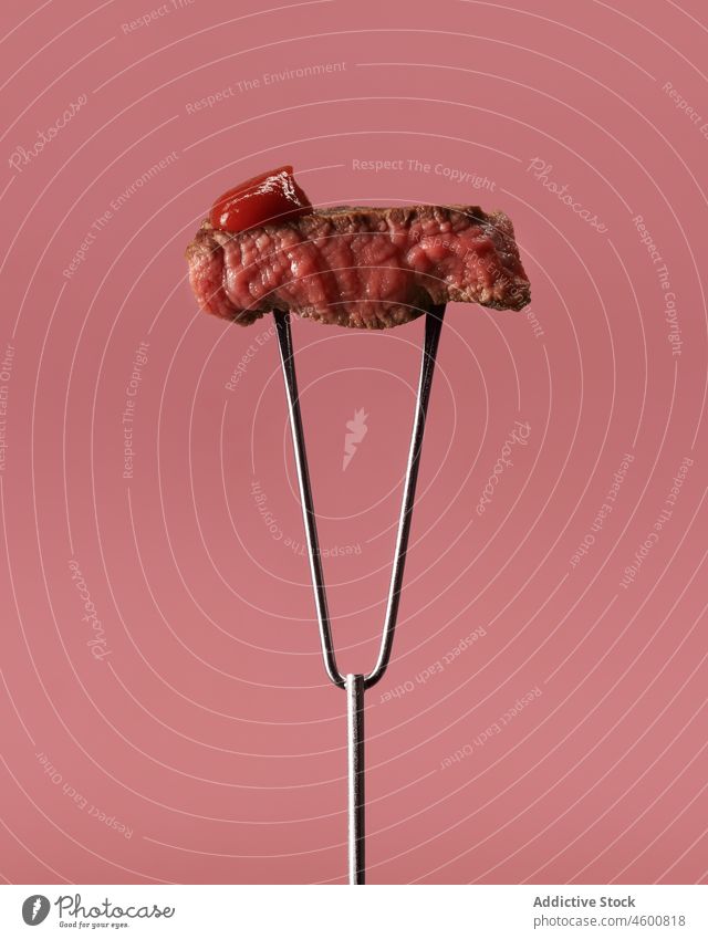 Leckeres gebratenes Fleisch auf Gabel gegen rosa Hintergrund Steak Ketchup appetitlich Rindfleisch lecker geschmackvoll Mahlzeit Lebensmittel Ernährung rostfrei