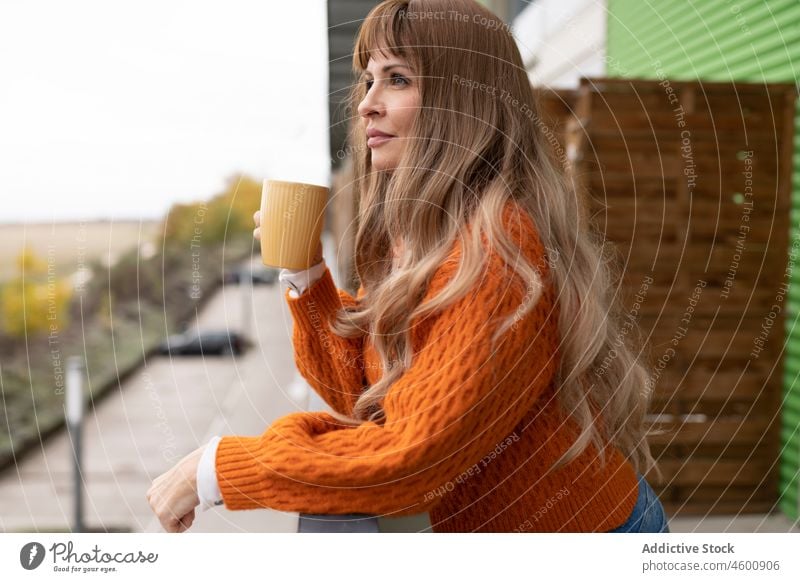 Frau trinkt Getränk auf Balkon Heißgetränk Terrasse trinken Zeitvertreib Erfrischung feminin verträumt Freizeit Dame Licht Becher Tasse Kaffee charmant