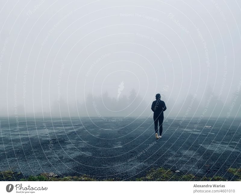 Dunkel oder schwarz gekleideter Wanderer im Nebel am Waldrand Nebelwand Nebelwald Nebelstimmung nebelig Nebelschleier Nebelmeer Nebeldecke waldgebiet