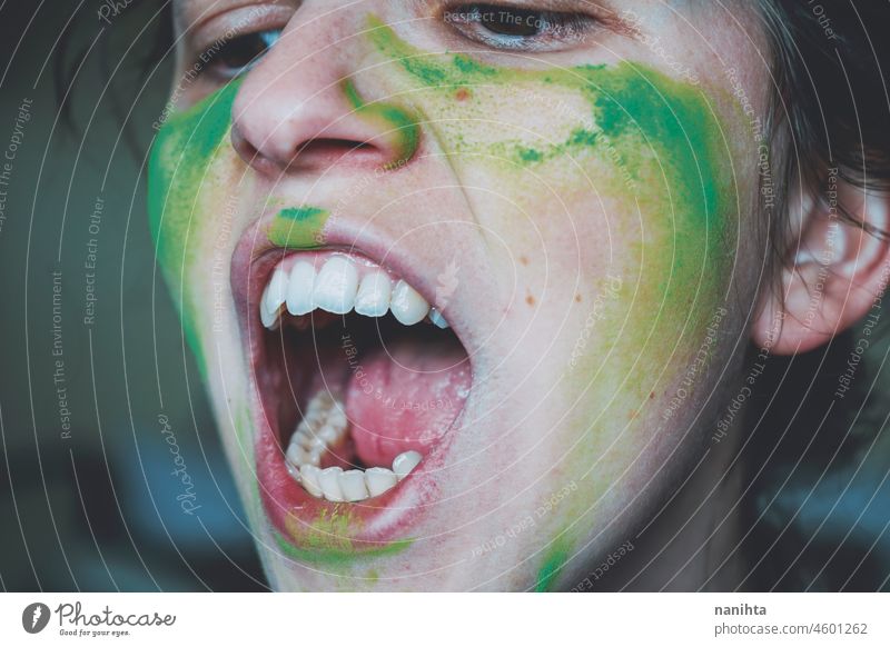 Wütende junge Frau, deren Gesicht mit grünem Staub bemalt ist Wut Krieger Zähne wirklich Farbe Malerei Haut schließen abschließen Emotion emotional