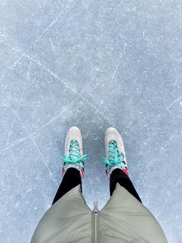 Die Beine einer Frau mit Schlittschuhen auf einer Eislaufbahn Eislaufen Schlittschuhlaufen Winter Eisfläche Wintersport Freizeit & Hobby Eislaufplatz