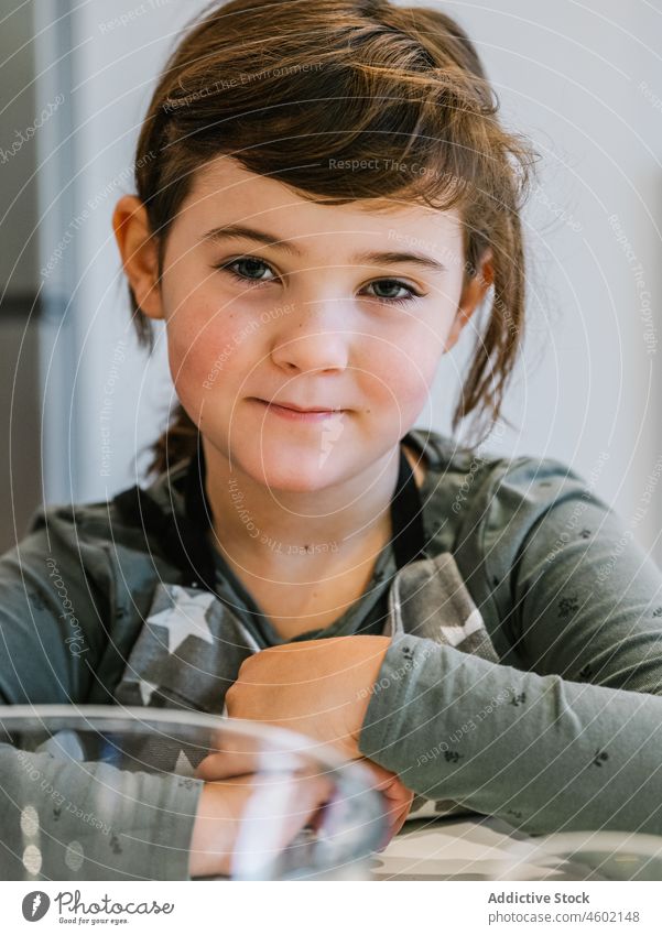 Kleines Mädchen in Schürze in der Küche Koch heimwärts Kind heimisch vorbereiten Küchengeräte kulinarisch braune Haare blaue Augen zu Hause charmant niedlich