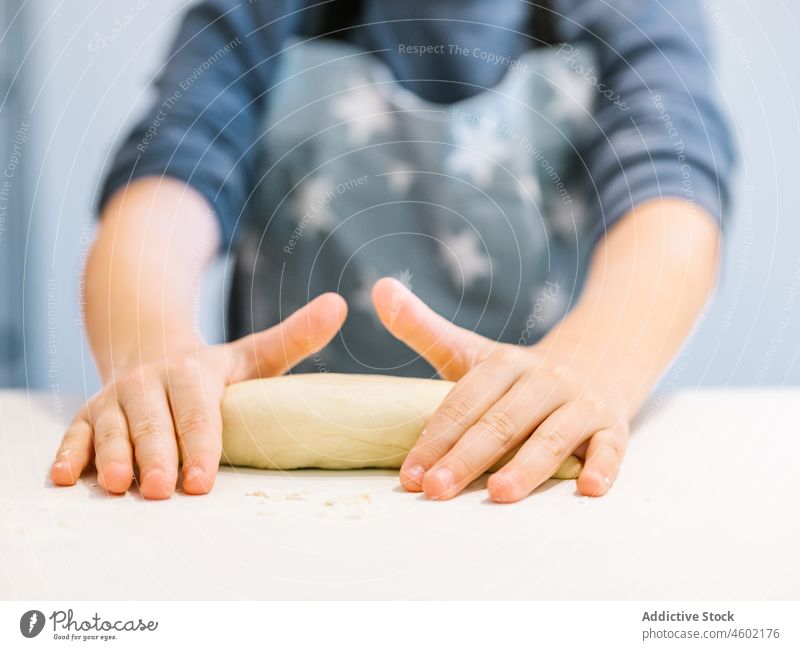 Anonymer Junge knetet Teig in der Küche Koch Kind Mehl kneten Gebäck Helfer Träne Schürze Prozess backen Lebensmittel heimisch Küchengeräte kulinarisch Produkt