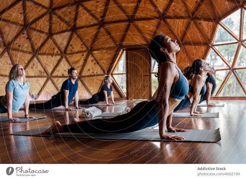 Menschen üben Cobra asana im Studio Yoga bhujangasana Kobra-Pose Asana Sitzung Gesunder Lebensstil Training Wellness Achtsamkeit passen beweglich Körperhaltung