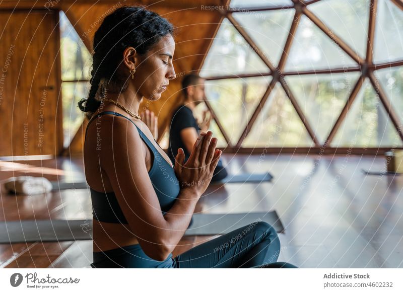 Schwarze Frau macht Namaste-Geste Menschengruppe salutieren Yoga Asana üben Gesunder Lebensstil meditieren Wellness Achtsamkeit passen Training Körperhaltung