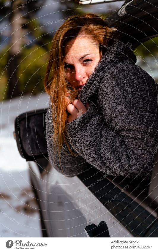 Junge Frau lehnt sich aus dem geöffneten Fenster eines Autos Winter Fahrer Wald PKW kalt ruhen Ausflug Autoreise Natur Fahrzeug warme Kleidung Automobil